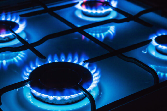 Burning,Blue,Gas,Focus,On,The,Front,Edge,Of,The Immagine di repertorio. Gas brucia su fornelli.