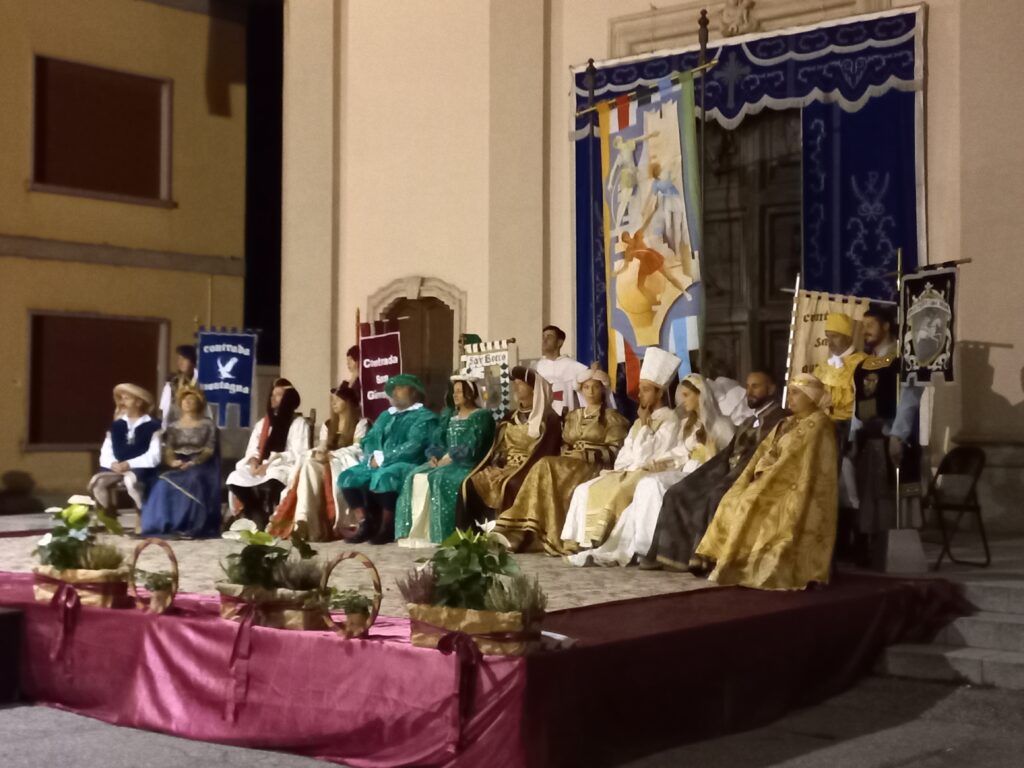 Palio di Fenegrò. I Capitani e le Dame del Palio. Alle loro spalle, il Palio e la Chiesa di Santa Maria Nascente.